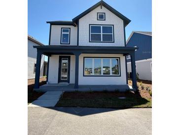 Charming two-story home featuring a welcoming porch and modern architectural details at 3089 Voyager Ave, St Cloud, FL 34771