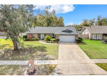 Charming single-story home with a well-manicured lawn, mature trees and an attached two car garage at 282 Lake Griffin Cir, Casselberry, FL 32707