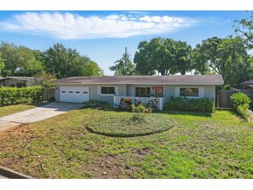 Charming single-story home with a well-manicured lawn and a cozy front porch at 1005 Catalpa Ln, Orlando, FL 32806