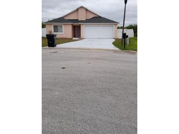 Charming single-Gathering home featuring an attached garage and driveway with front yard landscaping at 602 Hillcrest Dr, Davenport, FL 33897