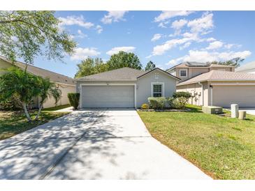 Charming single-story home with a well-maintained lawn and a two-car garage at 2076 Whispering Trails Blvd, Winter Haven, FL 33884