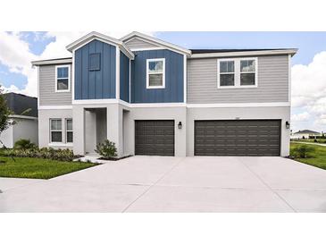 Two-story home with a spacious driveway, grey siding, and two-car garage at 1014 Brimstone Cir, Winter Haven, FL 33884