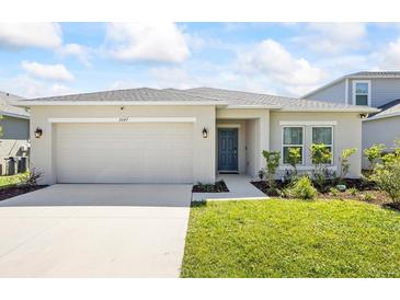 Charming single-story home with a two-car garage, well-maintained lawn, and beautiful landscaping at 2047 Rosewood Cir, Lakeland, FL 33810