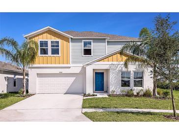 Charming two-story home with a bright blue front door and manicured landscaping at 1574 Sage Ave, Haines City, FL 33844