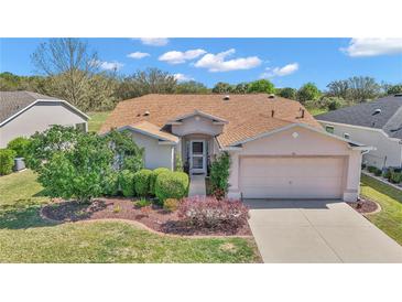 Charming single-story home with a well-manicured lawn and a two-car garage at 15213 Sw 14Th Avenue Rd, Ocala, FL 34473