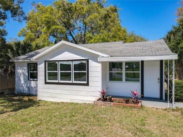 Charming single-story home with white siding, black trim windows, and a well-manicured front lawn at 218 W Magnolia St, Clermont, FL 34711