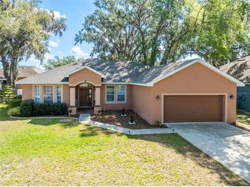 Charming one-story home featuring a well-manicured lawn and attached two-car garage at 5416 Oxford Manor Cir, Lakeland, FL 33810