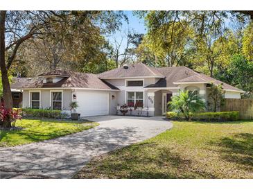 Charming single-story home with attached garage, well-manicured lawn, and mature trees at 638 Coral Way, Winter Springs, FL 32708
