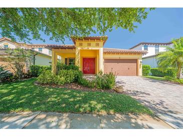 Charming single-Gathering home with a red front door, lush landscaping, and a paver driveway at 8427 Prestbury Dr, Orlando, FL 32832