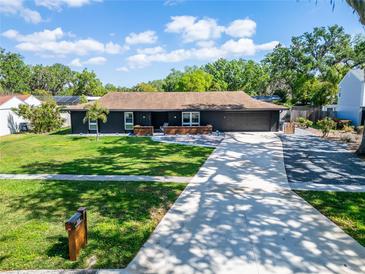 Beautiful single-story home with a dark exterior, well-manicured lawn, and a long driveway at 161 W Christina Blvd, Lakeland, FL 33813