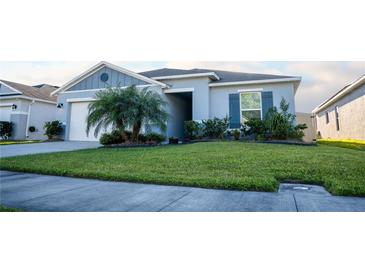 Charming single-story home featuring a well-manicured lawn, a lovely palm tree, and a neutral color palette at 4516 Casablanca Ave, Kissimmee, FL 34746