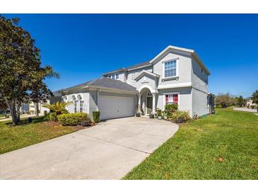 Two-story home with a well-maintained lawn, attached garage, and attractive curb appeal at 622 Copeland Dr, Haines City, FL 33844