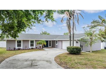 Charming single-story home featuring a circular driveway, attached garage, and well-maintained landscaping with palm trees at 4523 Oakglen Rd, Lakeland, FL 33813