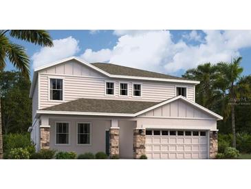 Inviting two-story home featuring a two-car garage, neutral siding and stone accents, complemented by lush landscaping and blue skies at 1931 Rider Rain Ln, Apopka, FL 32703