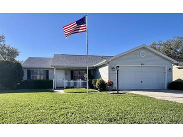 Charming single-story home featuring a well-manicured lawn and a prominent American flag at 620 San Pedro Dr, Lady Lake, FL 32159