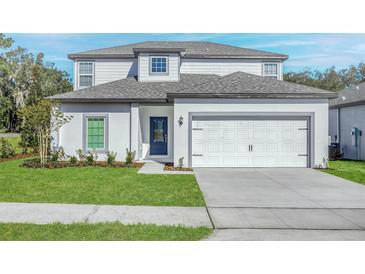 Charming two-story home with a well-manicured lawn and a two-car garage at 13430 Leaping Water Way, Astatula, FL 34705