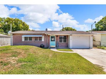 Charming brick home with a well-maintained lawn, blue door, and attached one-car garage at 1043 Pineview Pl, Lakeland, FL 33801