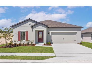 Charming single-story home with a well-manicured lawn, two car garage, and inviting front door at 1802 White Elephant Loop, Winter Haven, FL 33884