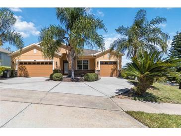 Charming single-Gathering home featuring a three-car garage, well-maintained landscaping, and lovely palm trees at 1892 Sanderling Dr, Clermont, FL 34711