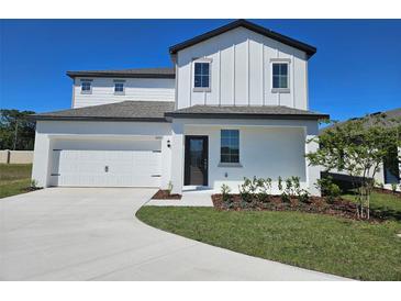 Charming two-story home featuring a two-car garage, manicured lawn, and beautifully painted exterior at 1653 Nantucket Way, Winter Haven, FL 33884