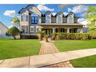 Charming two-story home featuring a manicured lawn, covered porch, and manicured garden at 3930 Cassia Dr, Orlando, FL 32828