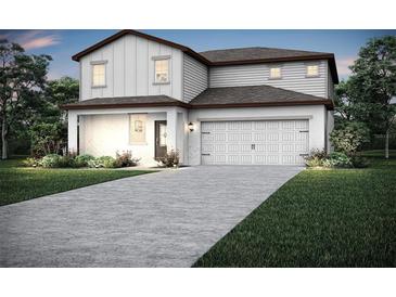 Charming two-story home featuring white siding, a two-car garage, and manicured landscaping at 1774 White Elephant Loop, Winter Haven, FL 33884