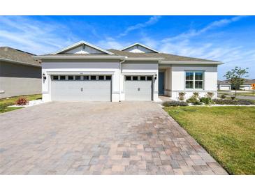 Charming home with a well-manicured lawn, a stone driveway, and a three car garage at 3158 Sailing Pier Ave, Winter Garden, FL 34787