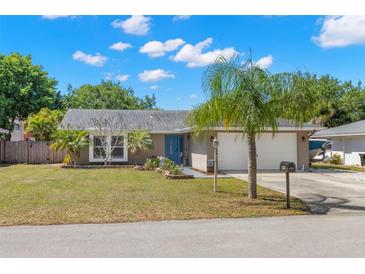 Charming single-story home featuring a well-manicured lawn, lush landscaping, and an attached two-car garage at 934 W Heron Cir, Winter Haven, FL 33884