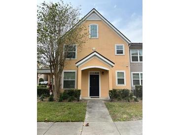 Inviting two-story townhome featuring a charming front porch and well-maintained landscaping at 3301 Soho St # 102, Orlando, FL 32835