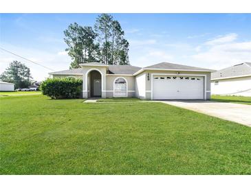 Charming single-story home with lush green lawn and attached two car garage at 143 Inconnu Ct, Kissimmee, FL 34759
