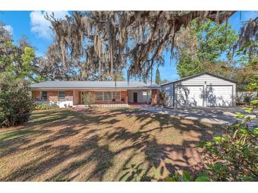 Charming single-story brick home featuring a metal roof and separate two car garage at 7013 Beverly Rd, Lakeland, FL 33813