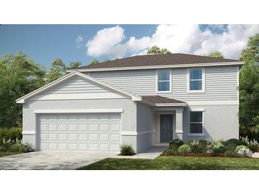 Charming two-story home with a two-car garage, landscaped yard, and light grey siding at 2418 Slippery Rock St, Auburndale, FL 33823