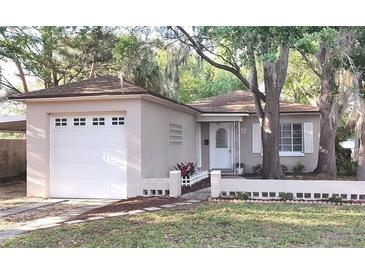 Charming single-story home with a well-maintained lawn, a one-car garage, and mature trees at 645 W Winter Park St, Orlando, FL 32804