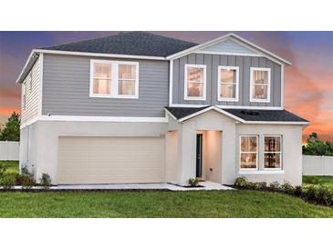 Two-story home featuring a gray exterior, attached two-car garage, and well-maintained front lawn at 2212 Canyon Oak Dr, Davenport, FL 33837