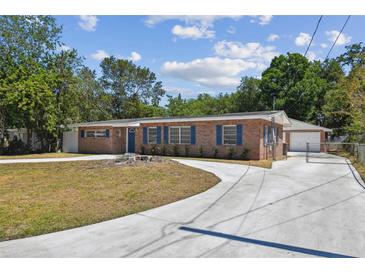 Charming brick home with blue shutters, lush landscaping, and a spacious driveway at 930 29Th Nw St, Winter Haven, FL 33881