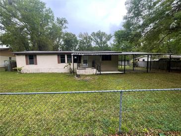 Backyard view of home featuring a covered carport and chain link fence at 1831 Quail Trl, Lakeland, FL 33810