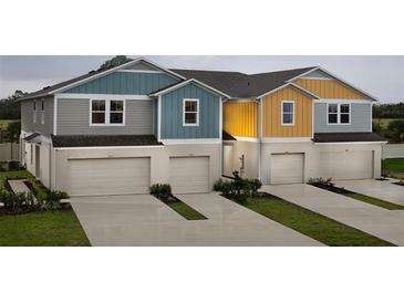 Colorful townhomes showcasing attached garages, neat landscaping, and individual driveways at 3856 King Hill Dr, Haines City, FL 33844