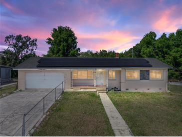 Charming single-story home showcasing solar panels, a front yard, and a classic design at 3928 Cherry Way, Lakeland, FL 33805