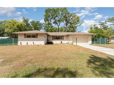 Charming single-story home featuring a spacious front yard and attached garage at 933 W Queen St, Lakeland, FL 33803
