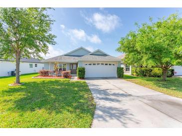 Charming single-story home with a well-manicured lawn and a two-car garage, enhancing curb appeal at 30505 Island Club Dr., Deer Island, FL 32778