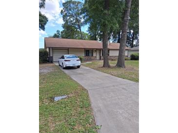A lovely single-story home with a long driveway and attached garage at 3400 Ne 43Rd Pl, Ocala, FL 34479