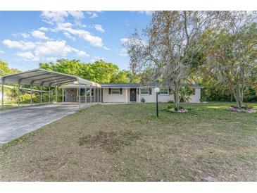 Charming single-story home featuring a covered carport, a well-maintained lawn, and mature trees at 803 Mccranie Rd, Lakeland, FL 33809