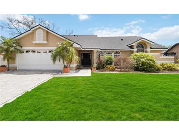 Charming one-story home with a manicured lawn, beautiful landscaping, and an attached two-car garage at 4014 Gallagher Loop, Casselberry, FL 32707