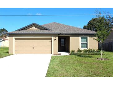 Charming single-story home with a well-manicured lawn and attached two-car garage at 58 Herring Ct, Poinciana, FL 34759