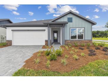 Charming single-story home showcasing a well-manicured lawn and a mix of stone and modern siding at 5950 Bristle Oak St, Mount Dora, FL 32757