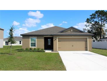 Charming one-story home with a well-maintained lawn and a two-car garage at 639 Gila Dr, Poinciana, FL 34759