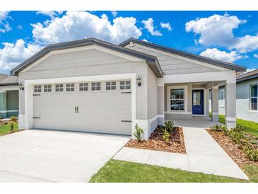 Charming single-story home with a two-car garage, covered entry and well manicured lawn at 3817 Corsican Pl, Lake Alfred, FL 33850
