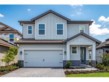 Charming two-story home featuring a two-car garage, stone accents, and a well-manicured front yard at 7869 Somersworth Dr, Kissimmee, FL 34747