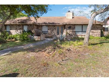 Charming single-story brick home featuring a well-kept lawn, mature trees and a cozy entrance at 132 Margate Mews, Longwood, FL 32779