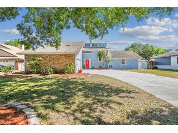 Charming light blue two-story home with brick accents and a vibrant red front door at 4133 Staffordshire Dr, Lakeland, FL 33809